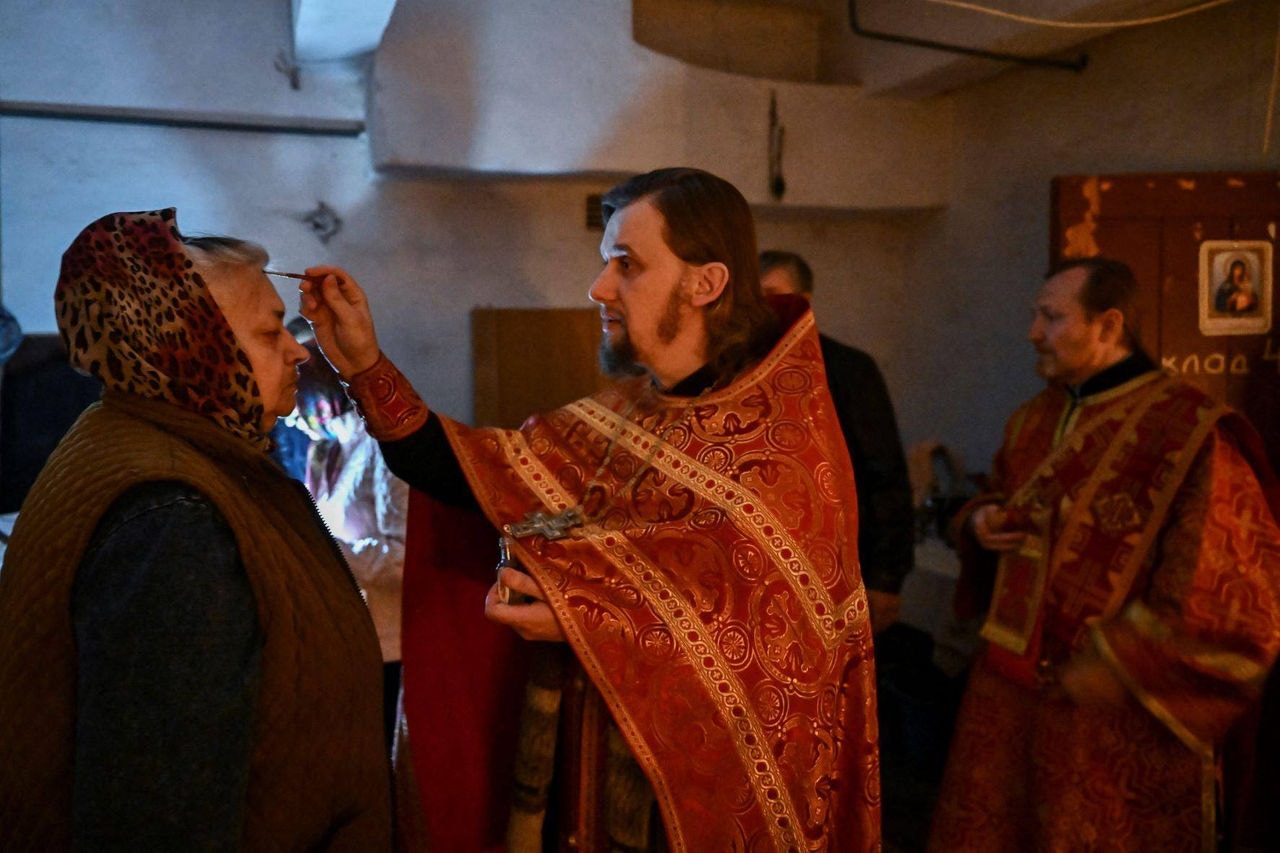 Padre da Igreja Ortodoxa reza com fiéis na região de Donbas, leste da Ucrânia