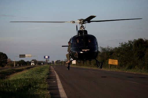 A helicopter used by rescue teams lands in the middle of the BR-116 highaway in Eldorado do Sul, Rio Grande do Sul, Brazil on May 9, 2024. Teams raced against the clock Thursday to deliver aid to flood-stricken communities in southern Brazil before the arrival of new storms forecast to batter the region again. Some 400 municipalities have been affected by the worst natural calamity ever to hit the state of Rio Grande do Sul, with at least 107 people dead and hundreds injured. (Photo by Anselmo CUNHA / AFP)
