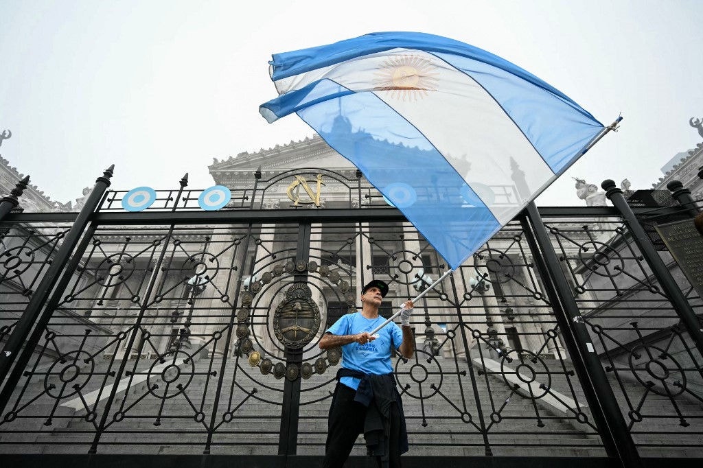 Manifestante agita a bandeira argentina em frente ao Congresso Nacional em Buenos Aires