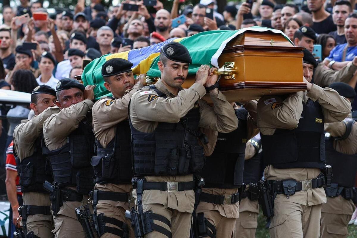 Policiais militares carregam o caixão do sargento Roger Dias