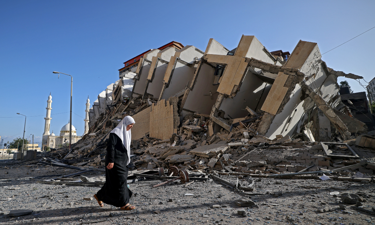 Fotógrafo registra mulher palestina caminhando após ataque israelense
