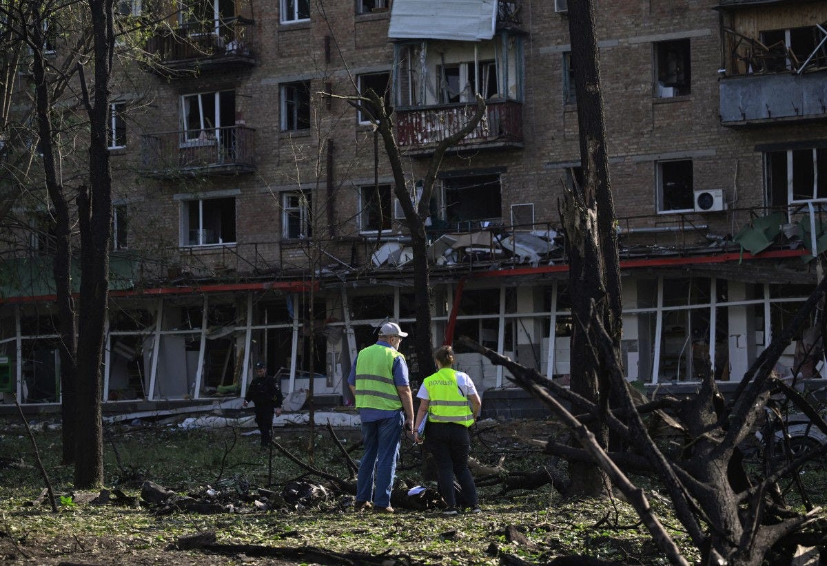 Police officers work as they stand at the site of a damaged residential building following a Russian missile and drone strike in Kyiv on June 17, 2025, amid the Russian invasion of Ukraine. A Russian attack on Ukraine killed at least 14 people and wounded dozens in the capital, authorities said on June 17, with more wounded reported in the Odesa and Chernigiv regions. (Photo by Genya SAVILOV / AFP)