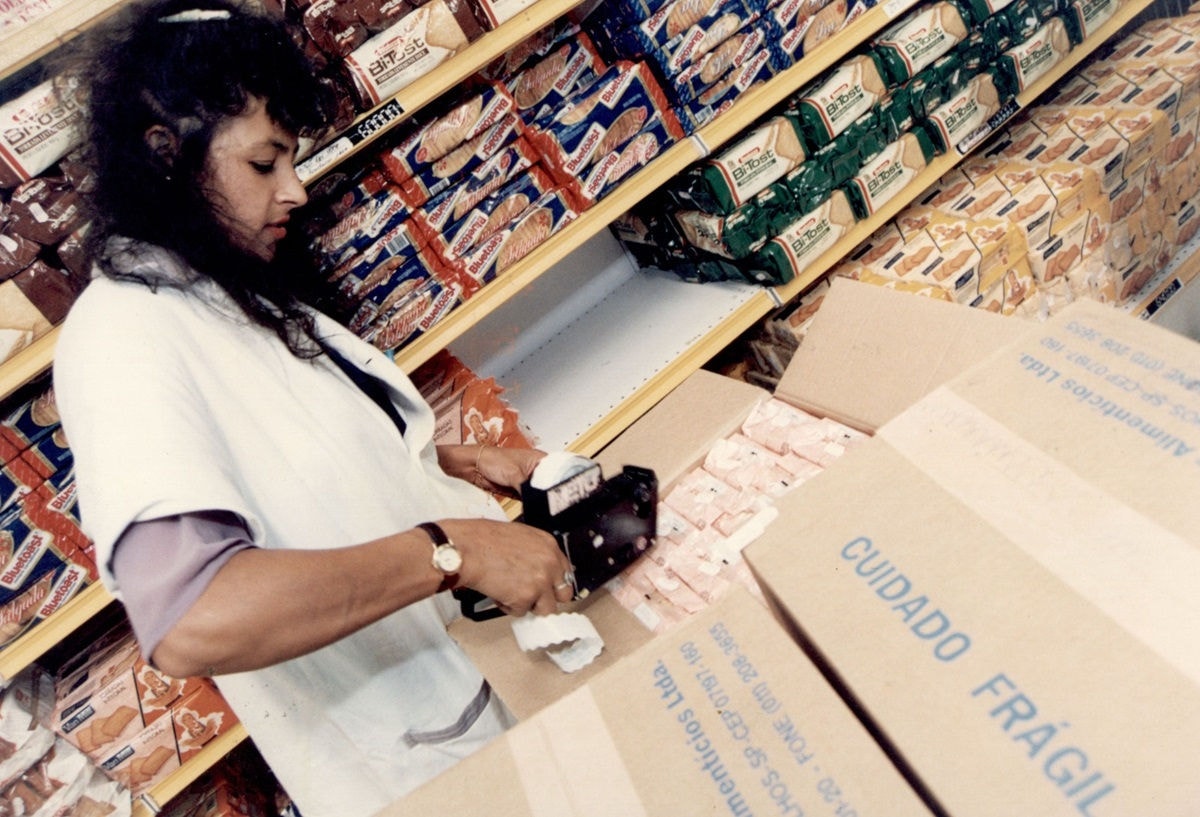 Funcionária remarca preços com etiquetadoras no supermercado em São Paulo com a chegada do URV