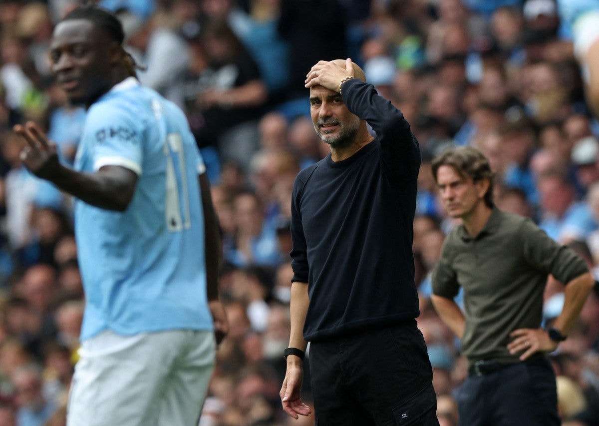 O técnico espanhol do Manchester City, Pep Guardiola (C), e o técnico dinamarquês do Tottenham Hotspur, Thomas Frank (D), reagem durante a partida no Etihad Stadium em Manchester