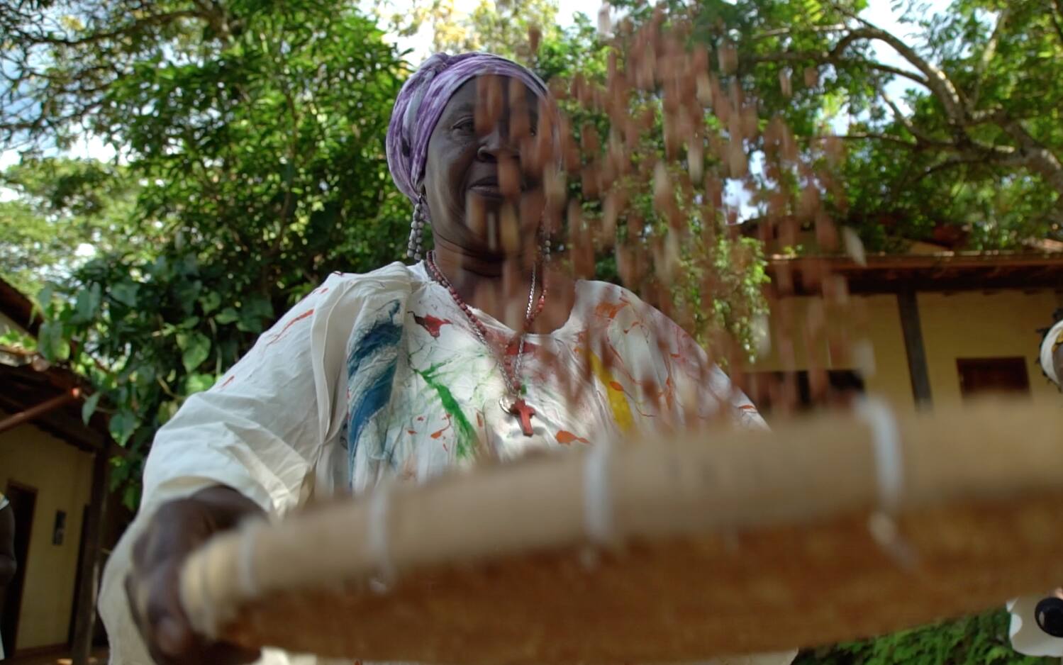 Mulher realiza dança com peneira, em celebração à boa colheita, no Quilombo dos Rodrigues, em Brumadinho, na RMBH