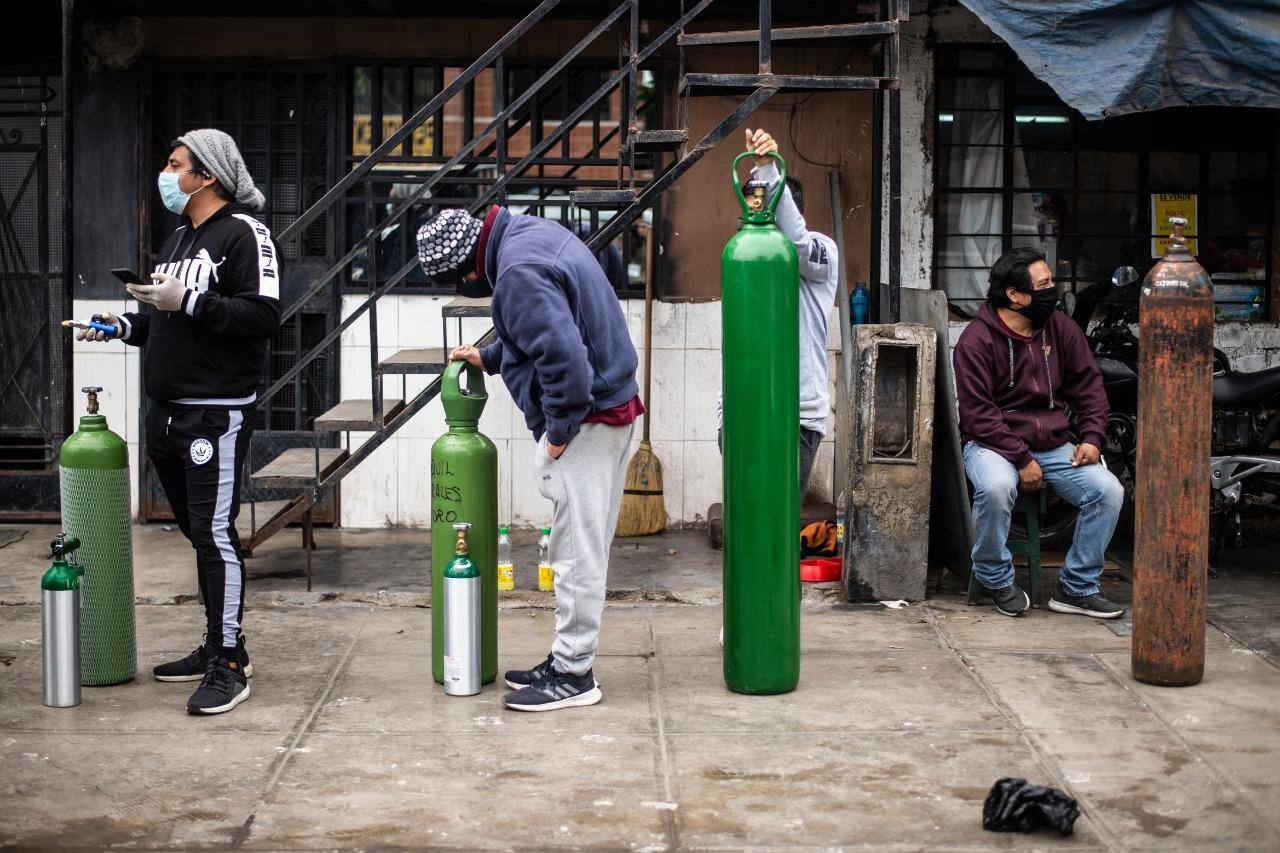 Pessoas fazem fila para reabastecer  cilindros de oxigênio vazios em Callao, no Peru
