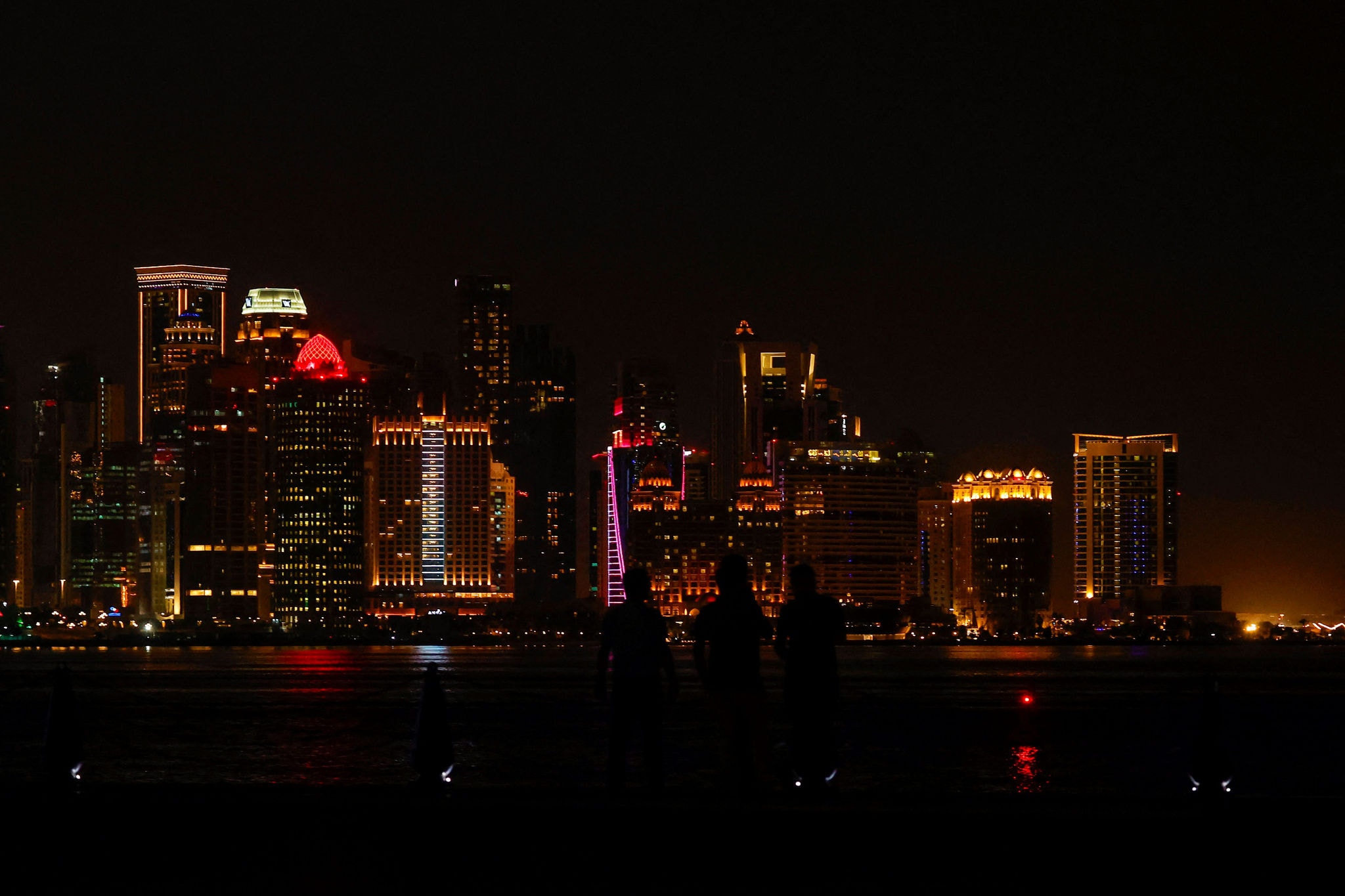 Pessoas na cornija de Doha com vista para arranha-céus, no Catar, em 23 de junho de 2025