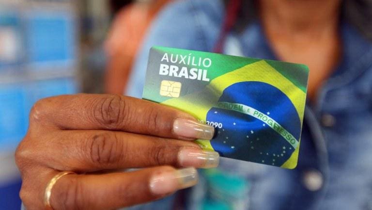 Imagem ilustrativa de uma pessoa segurando o cartão do Auxílio Brasil