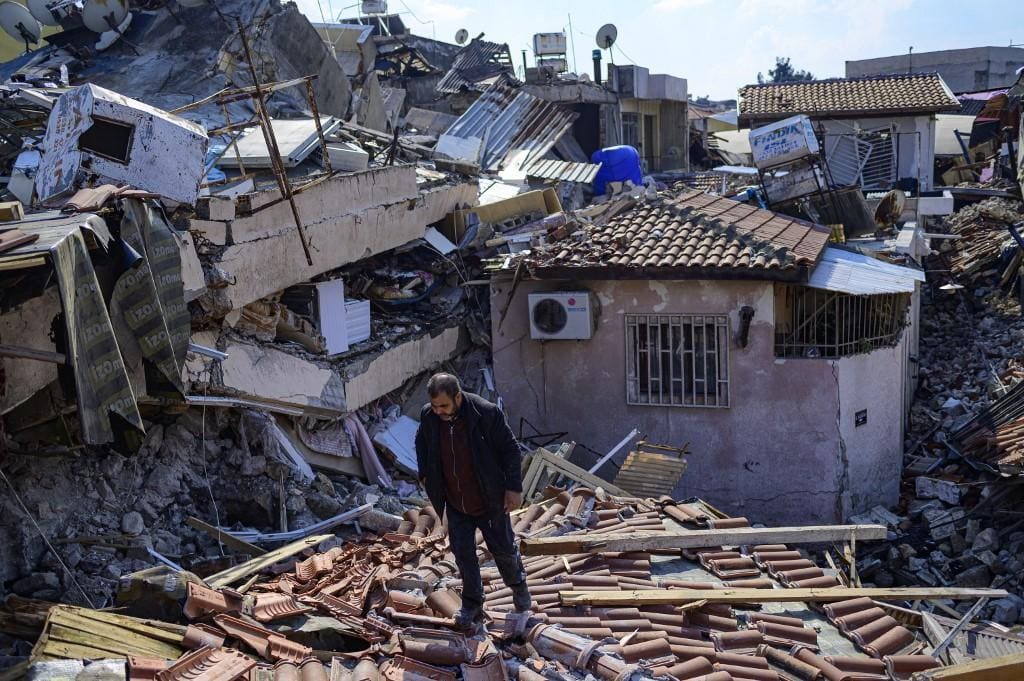 Morador observa sua casa destruída na cidade de Hatai, na Anatólia Turca, após o tremor que causou a morte de 25 mil pessoas até sabado (112)