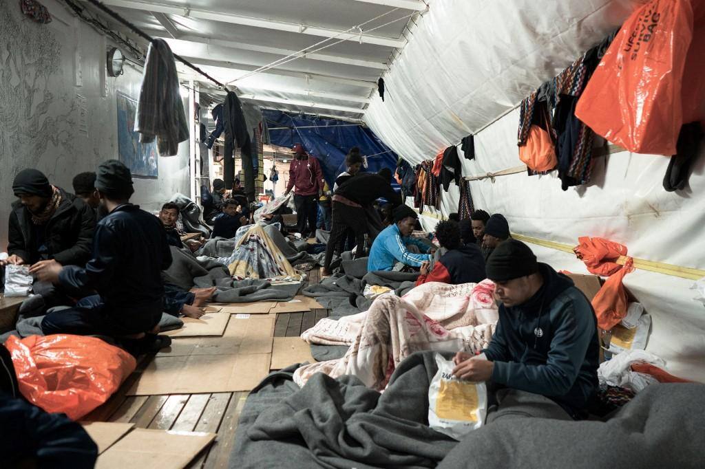 imigrantes aguardam dentro de navio na itália