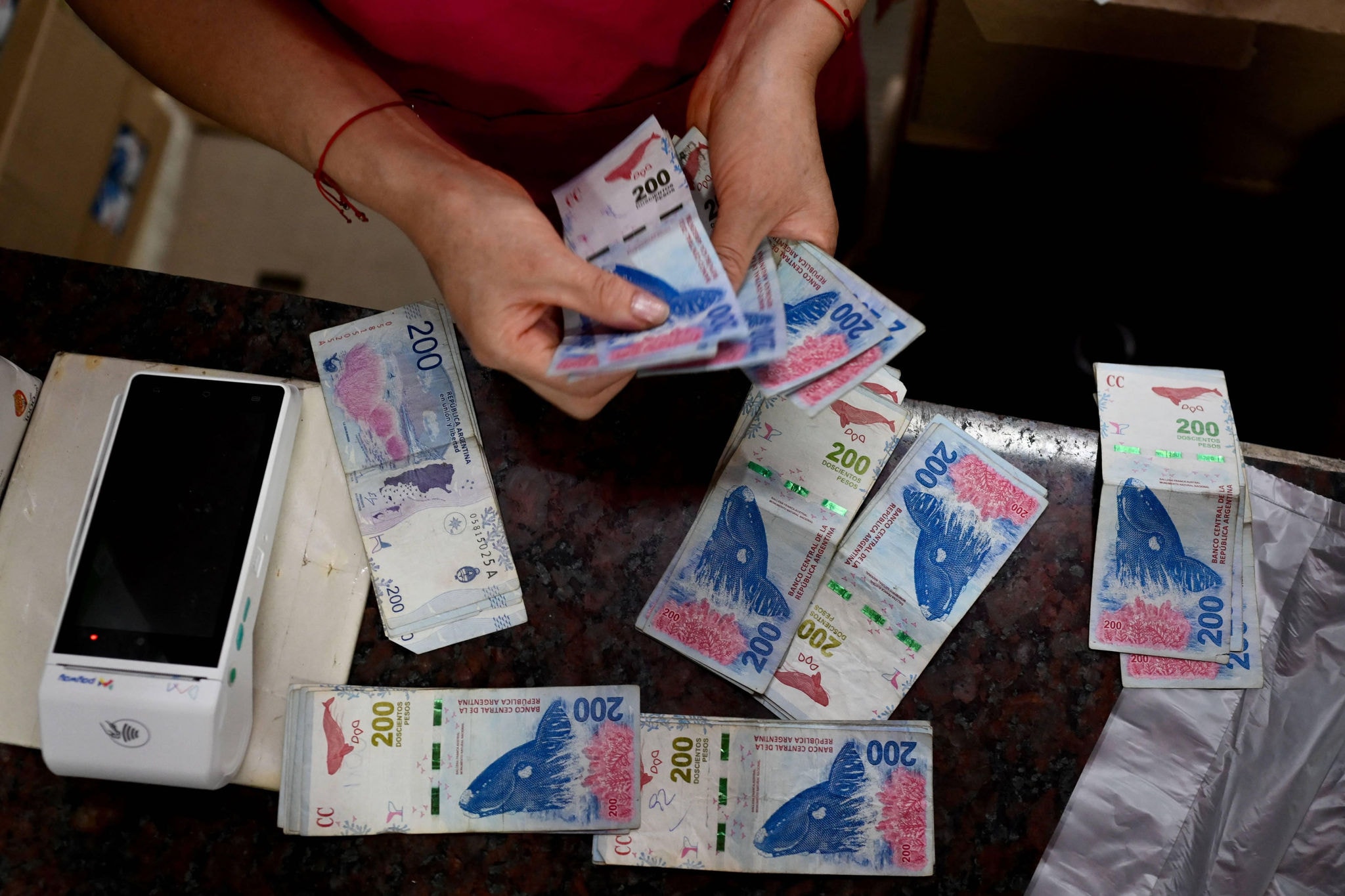 Mulher conta pesos argentinos