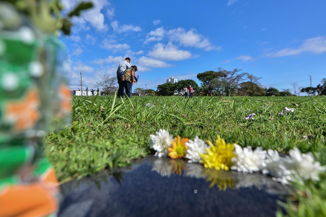 Pessoas prestam homenagens a entes queridos no cemitério da Paz, em BH