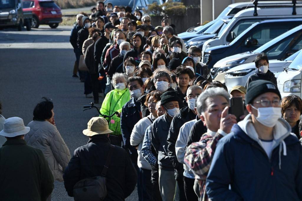 Fila na cidade de Shika para receber suprimentos, após terremoto devastador