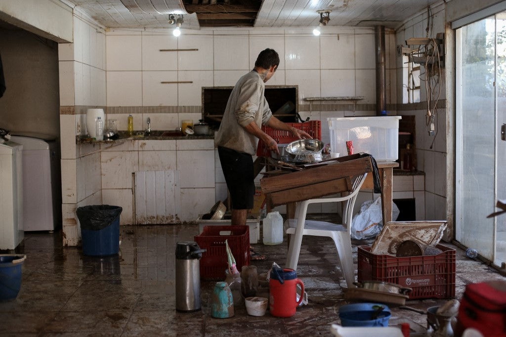 Homem limpa a casa após enchente em São Sebastião do Cai, no Rio Grande do Sul