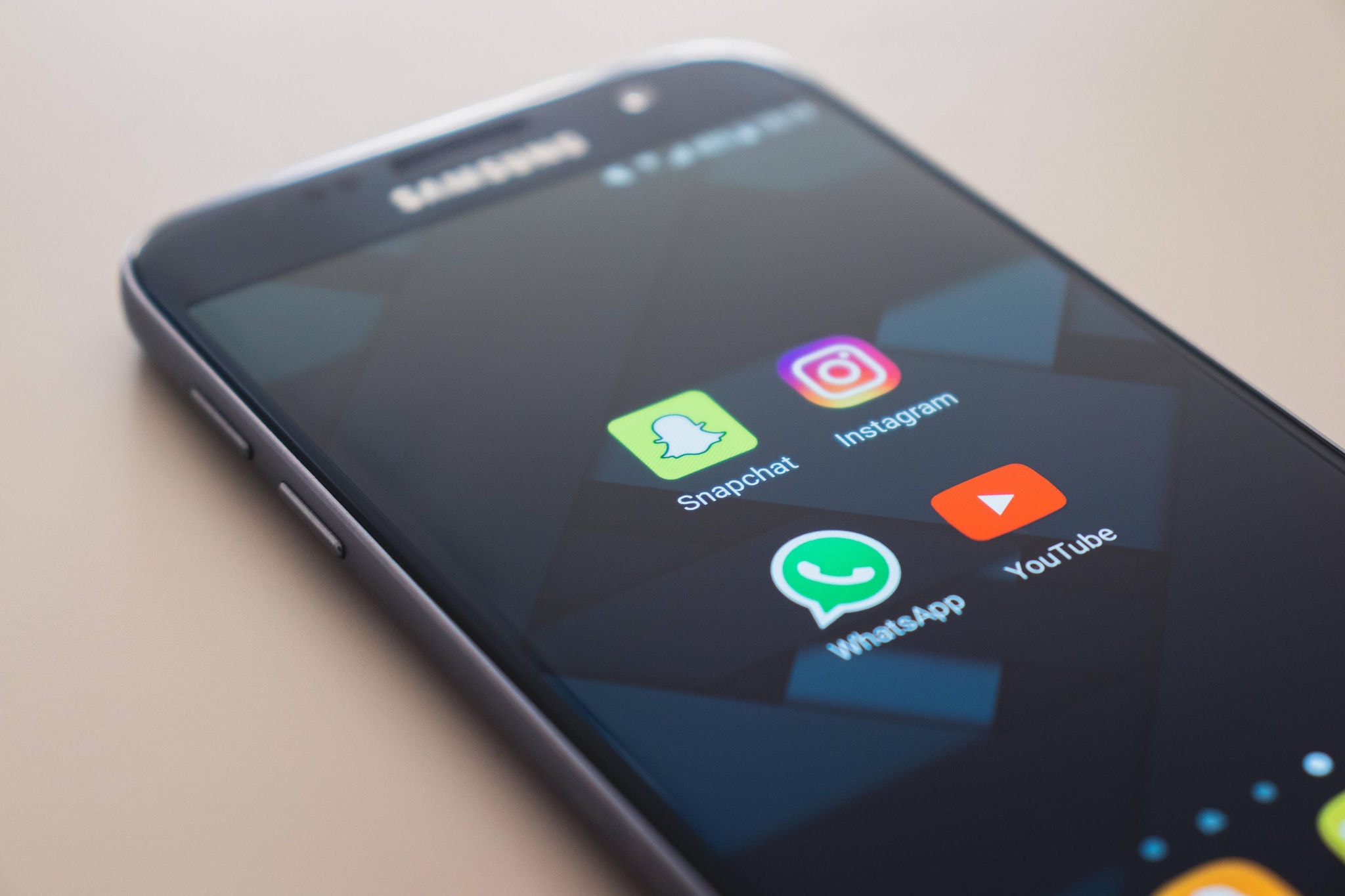 Na imagem, um celular mostrando aplicativos de redes sociais como Whatsapp, Youtube, Snapchat e Instagram