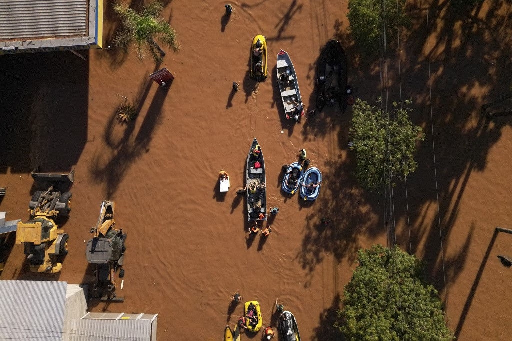 Voluntários e bombeiros resgatam moradores nas ruas de Porto Alegre (RS)