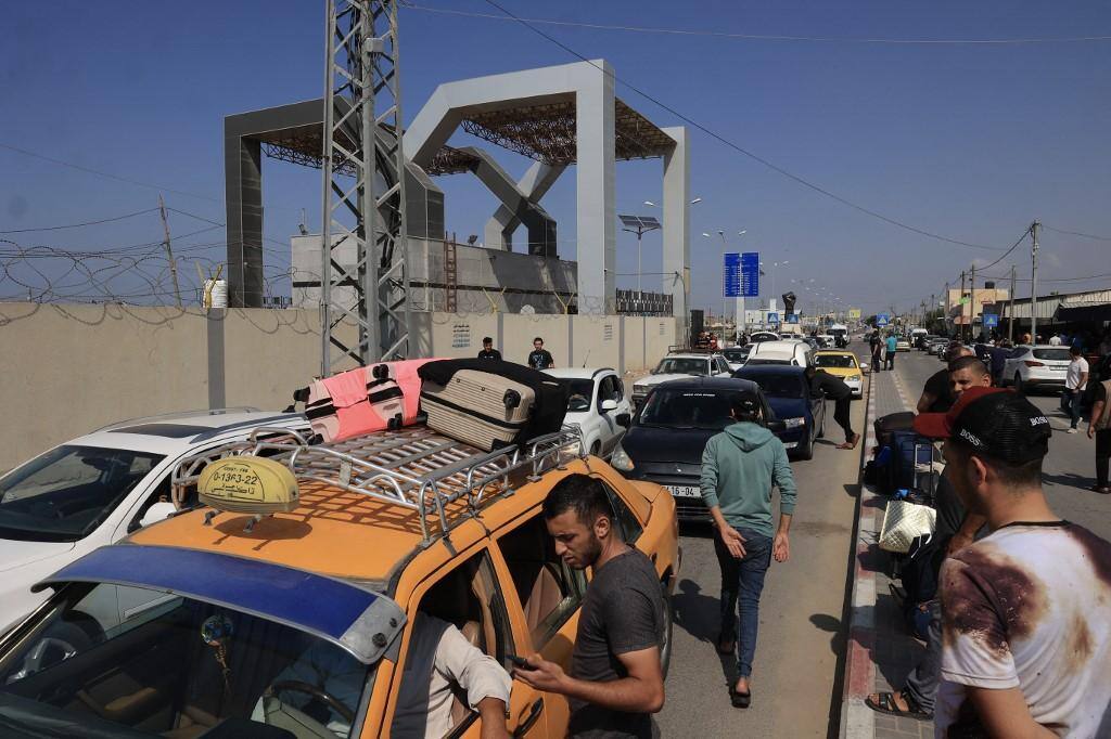 Fila de palestinos e estrangeiros na passagem de Rafah, de Gaza para o Egito, aguardando a liberação para deixar a região de conflito