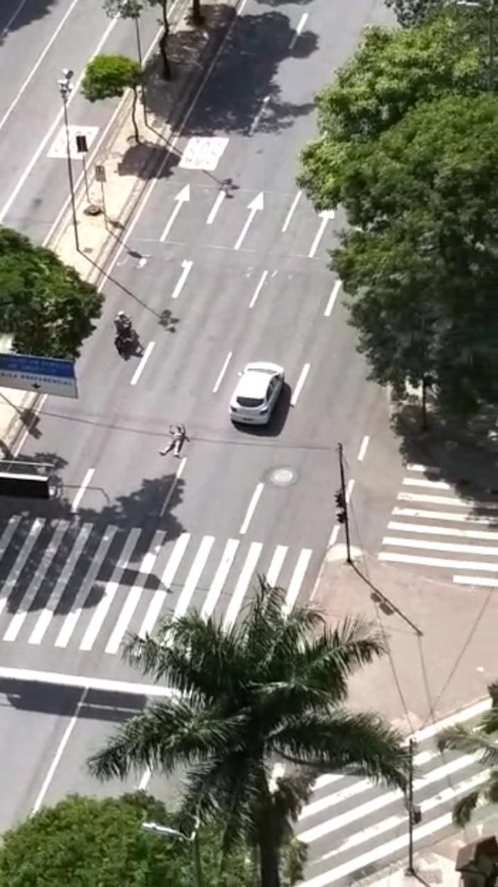 Em um determinado momento, um carro e uma moto chegam a passar bem próximo ao homem