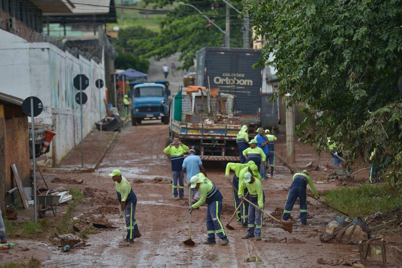 Funcionários de limpeza tentam tirar a lama da avenida