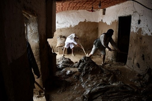 Afghan men shovel mud from a house following flash floods after heavy rainfall at a village in Baghlan-e-Markazi district of Baghlan province on May 11, 2024. More than 300 people were killed in flash flooding in Afghanistan's northern province of Baghlan, the World Food Programme said on May 11. (Photo by Atif Aryan / AFP)