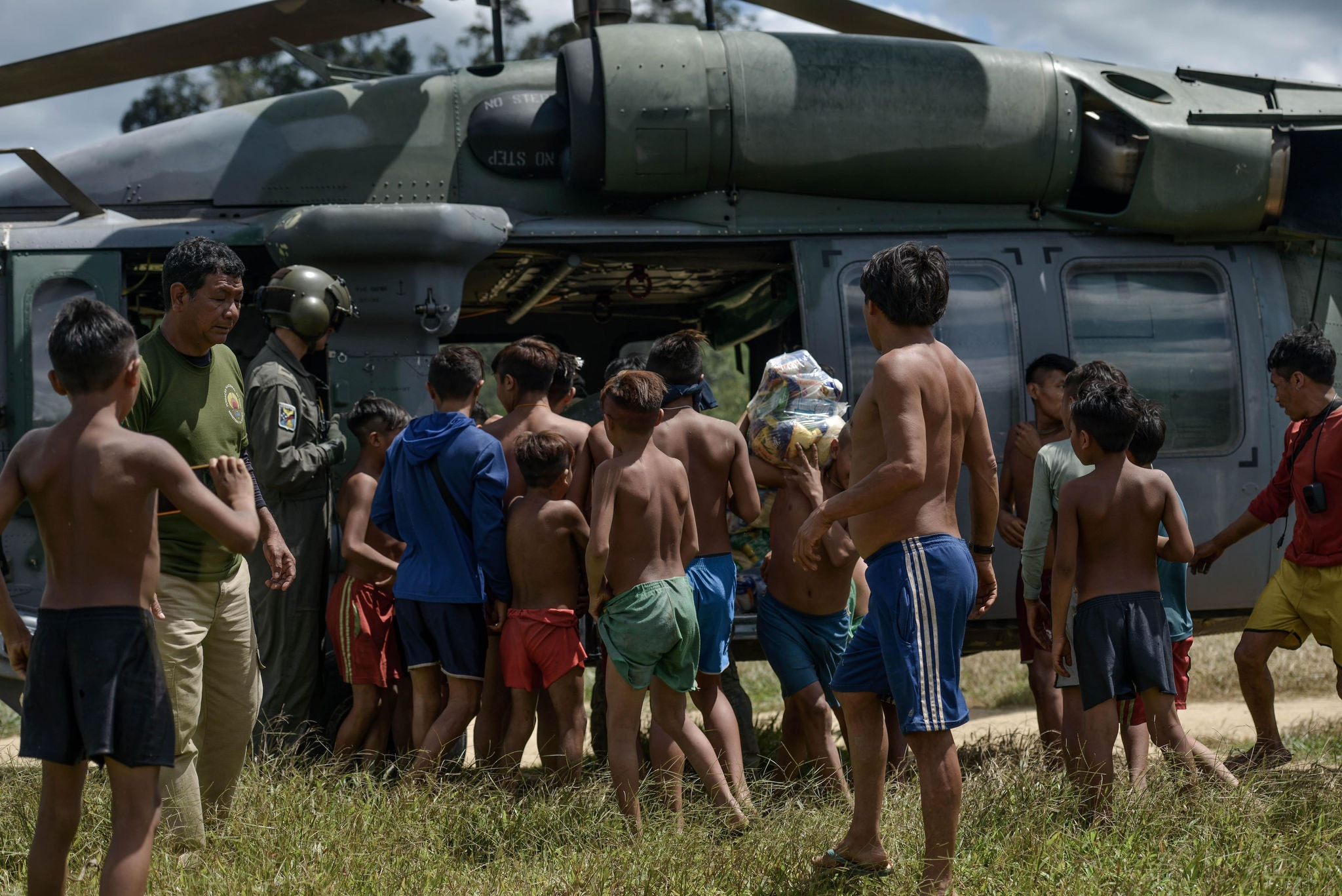 Dezenas de indígenas se aproximam de helicóptero para receber cestas básicas: expansão do do garimpo gerou cenário de fome. Fotos: Fred Magno/O Tempo