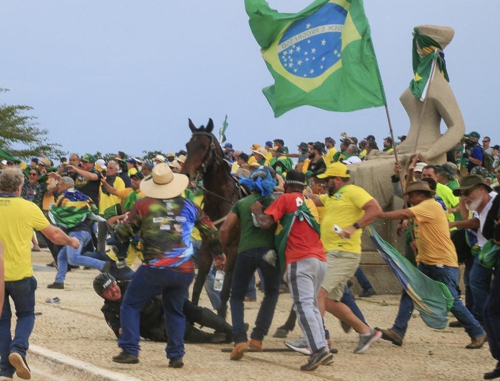 Apoiadores do ex-presidente Jair Bolsonaro derrubam policial militar do cavalo durante os atos de 8 de janeiro de 2023