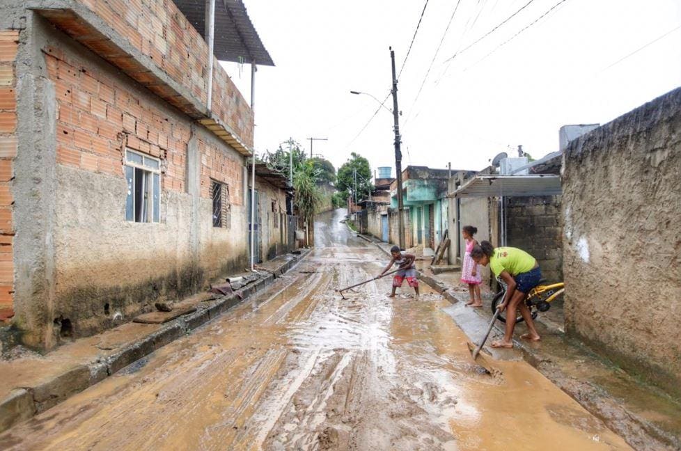 Moradores limpam a rua, que ficou tomada pela lama