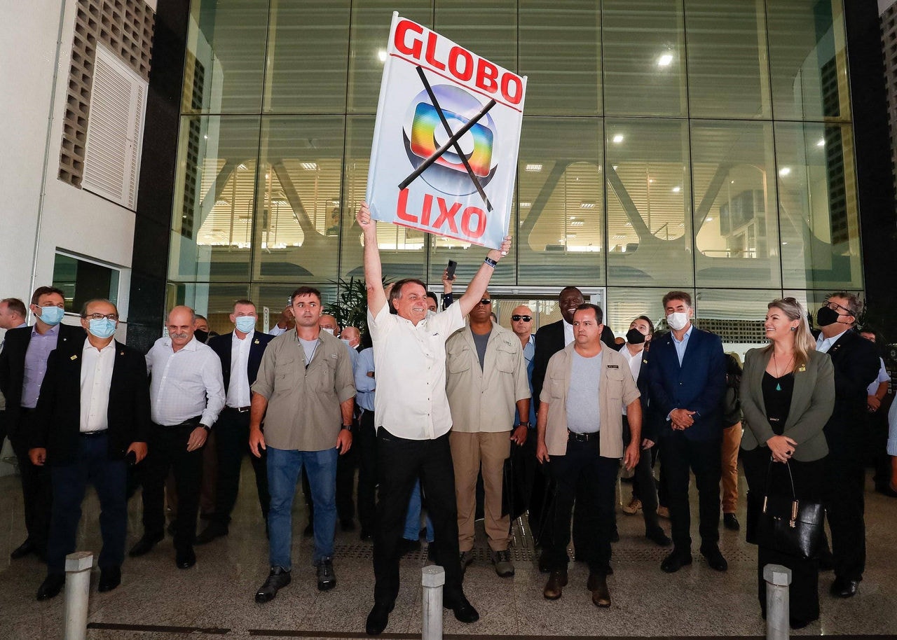 Bolsonaro com placa xingando a TV Globo
