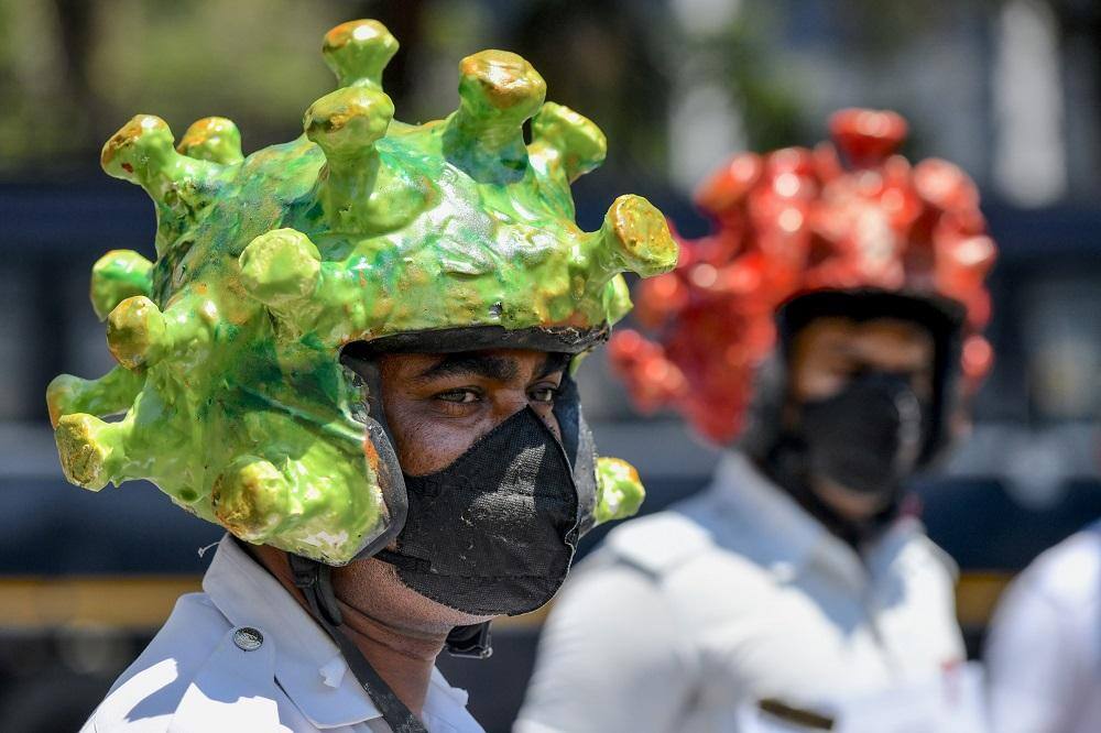 Na Índia, até mesmo os policiais resolveram andar com capacetes de coronavírus para conscientizar a população