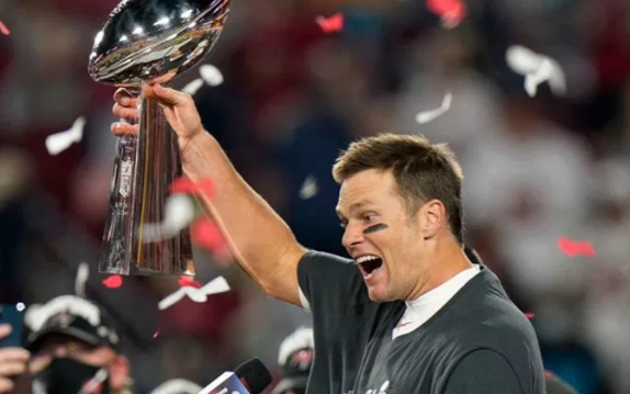 Tom Brady, maior vencedor de Super Bowls da NFL, segurando o trofeu Vince Lombardi