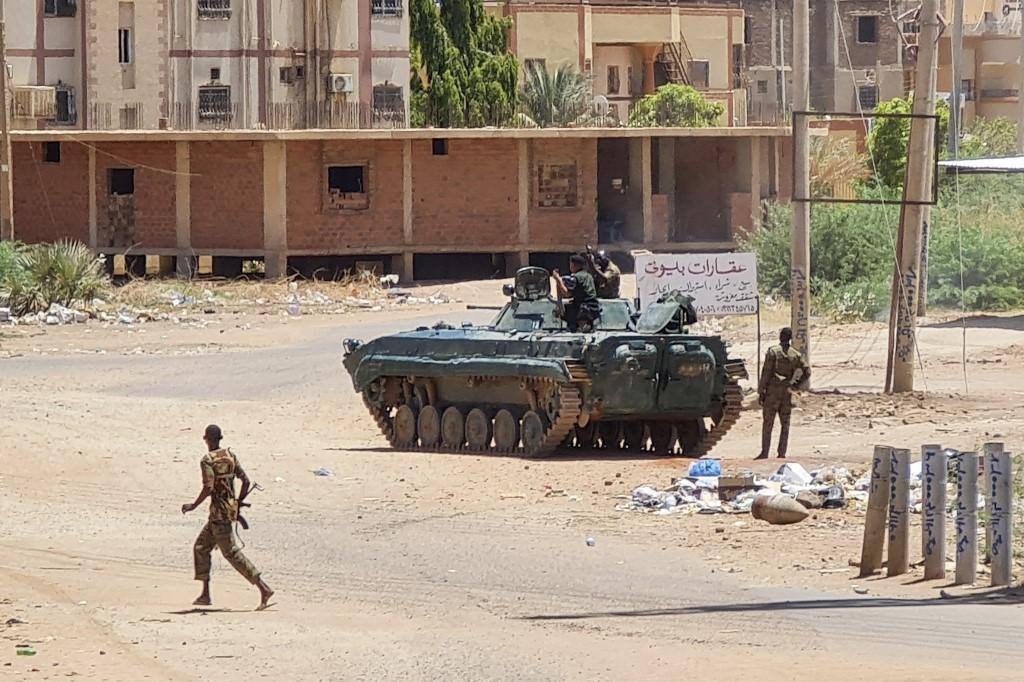 Militares sudaneses se movimentam em torno de blindado nas ruas de Cartum, capital do Sudão, em meio aos conflitos com paramilitares