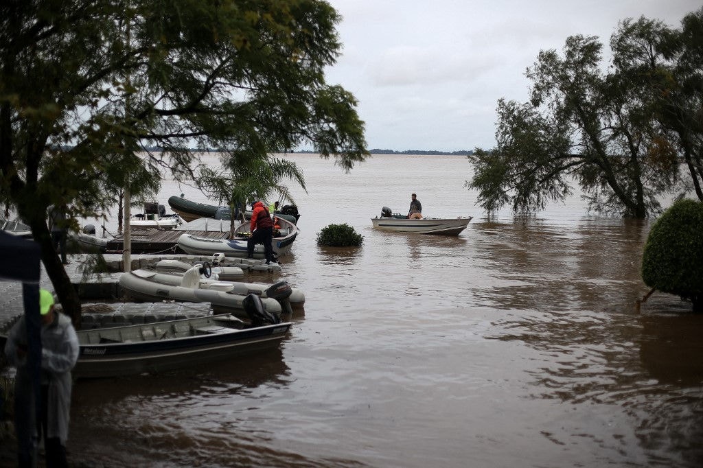 Pessoas em uma pequena embarcação em uma enchente no Rio Grande do Sul (ANSELMO CUNHA / AFP)