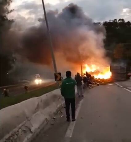 Caminhão pega fogo na BR-381 em MG e pessoas se arriscam para saquear carga