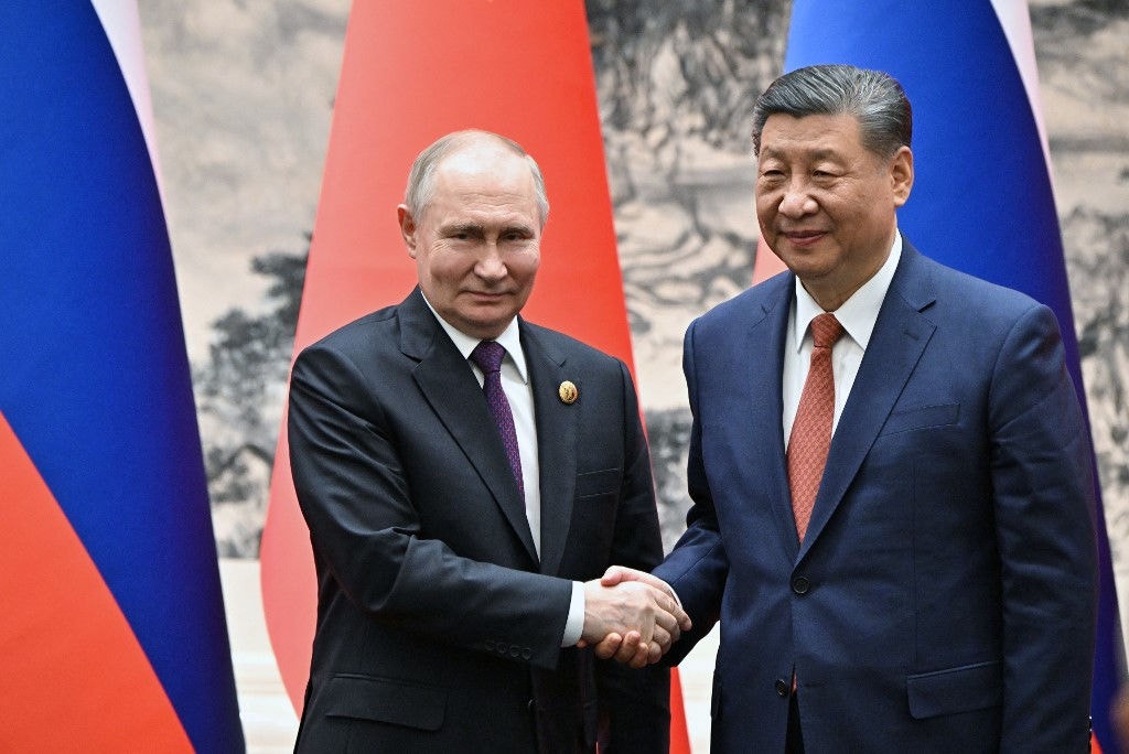 O presidente da Rússia, Vladimir Putin, e o presidente da China, Xi Jinping, apertam as mãos durante reunião em Pequim
