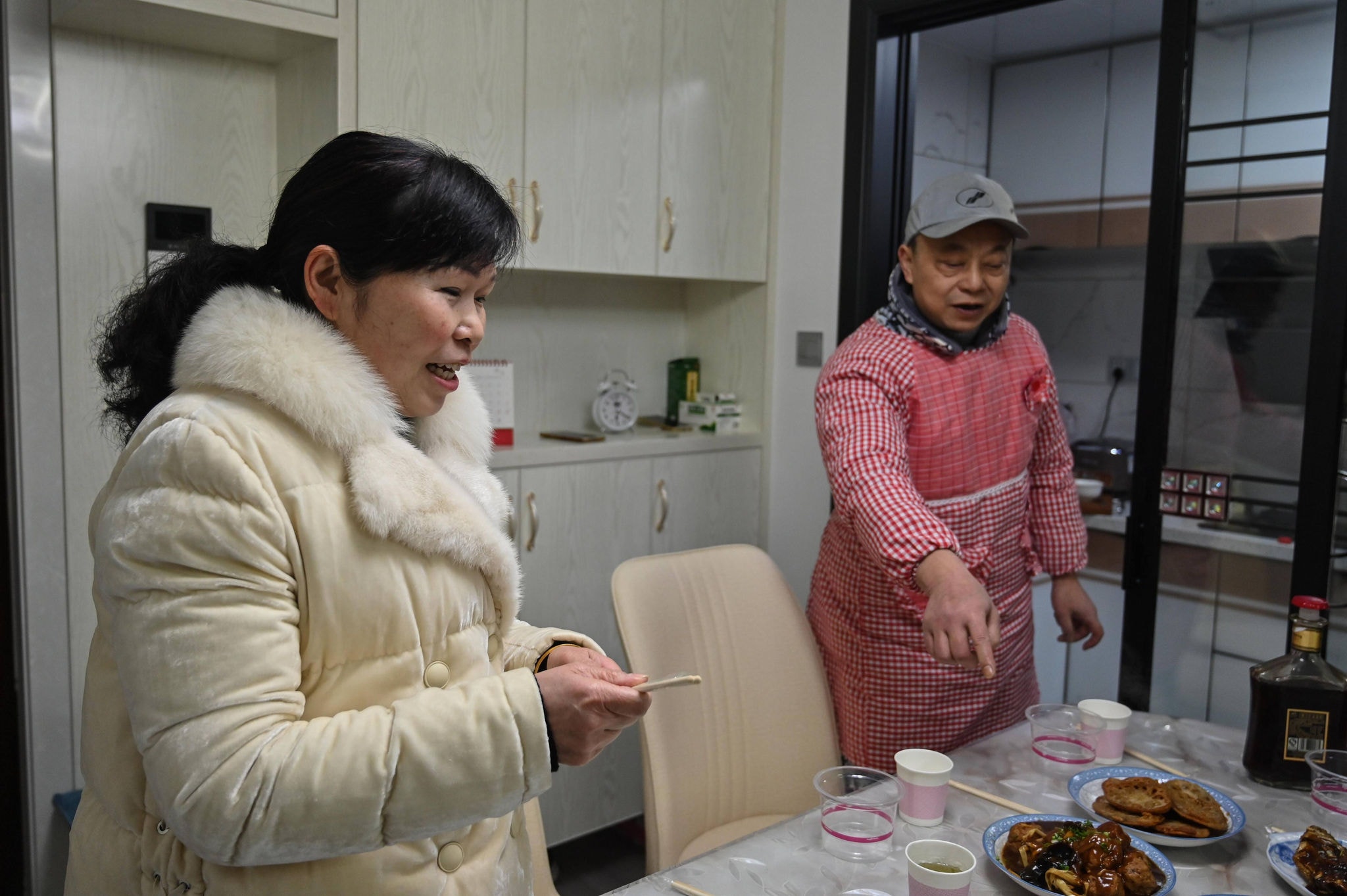 Morador de Wuhan, Pen Lixing prepara o jantar com sua esposa Wang Yangong para celebrar o ano novo chinês em casa
