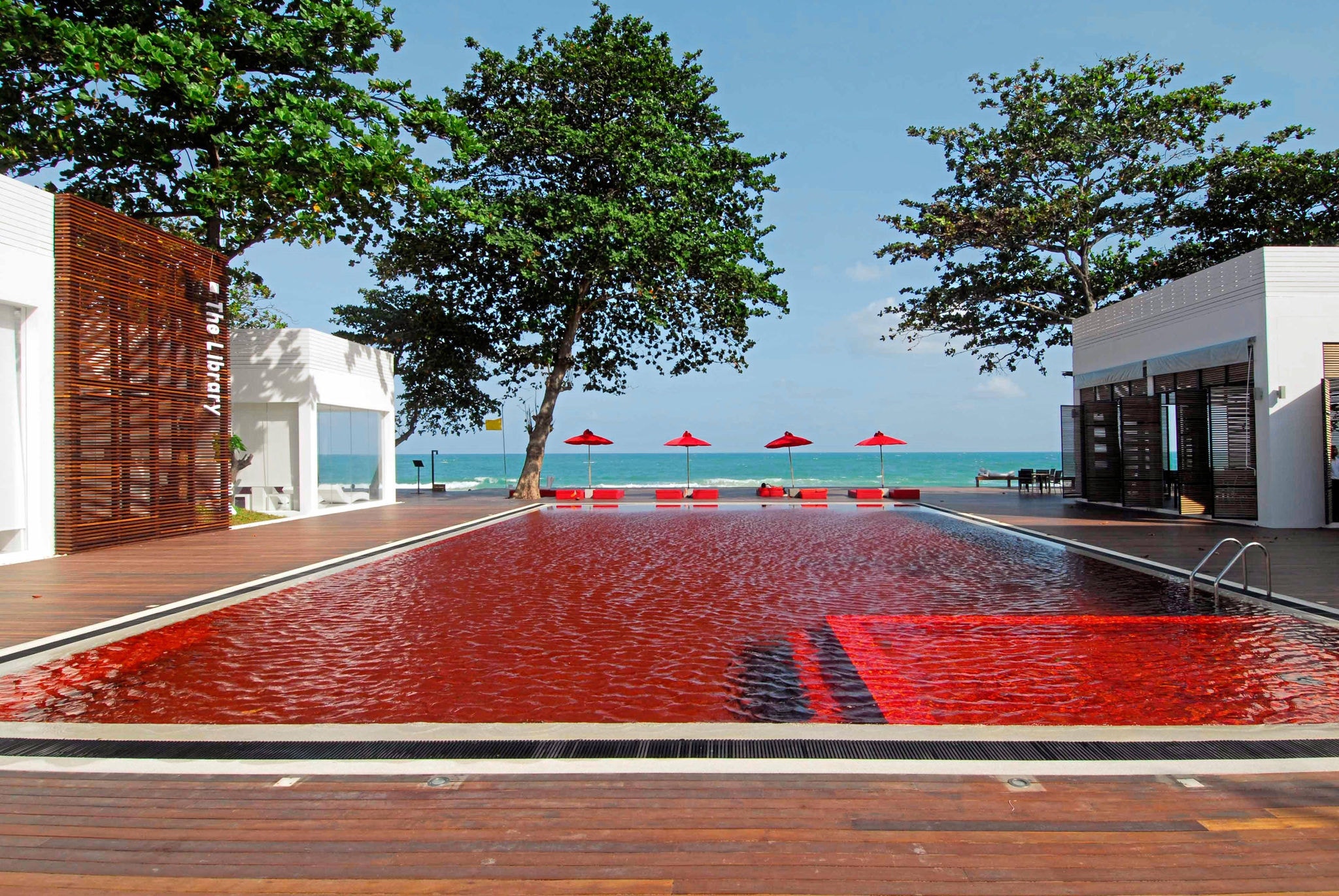 A piscina no resort The Library, na Tailândia, obtém essa cor a partir de uma base de mosaico de vidro em laranja, amarelo e vermelho