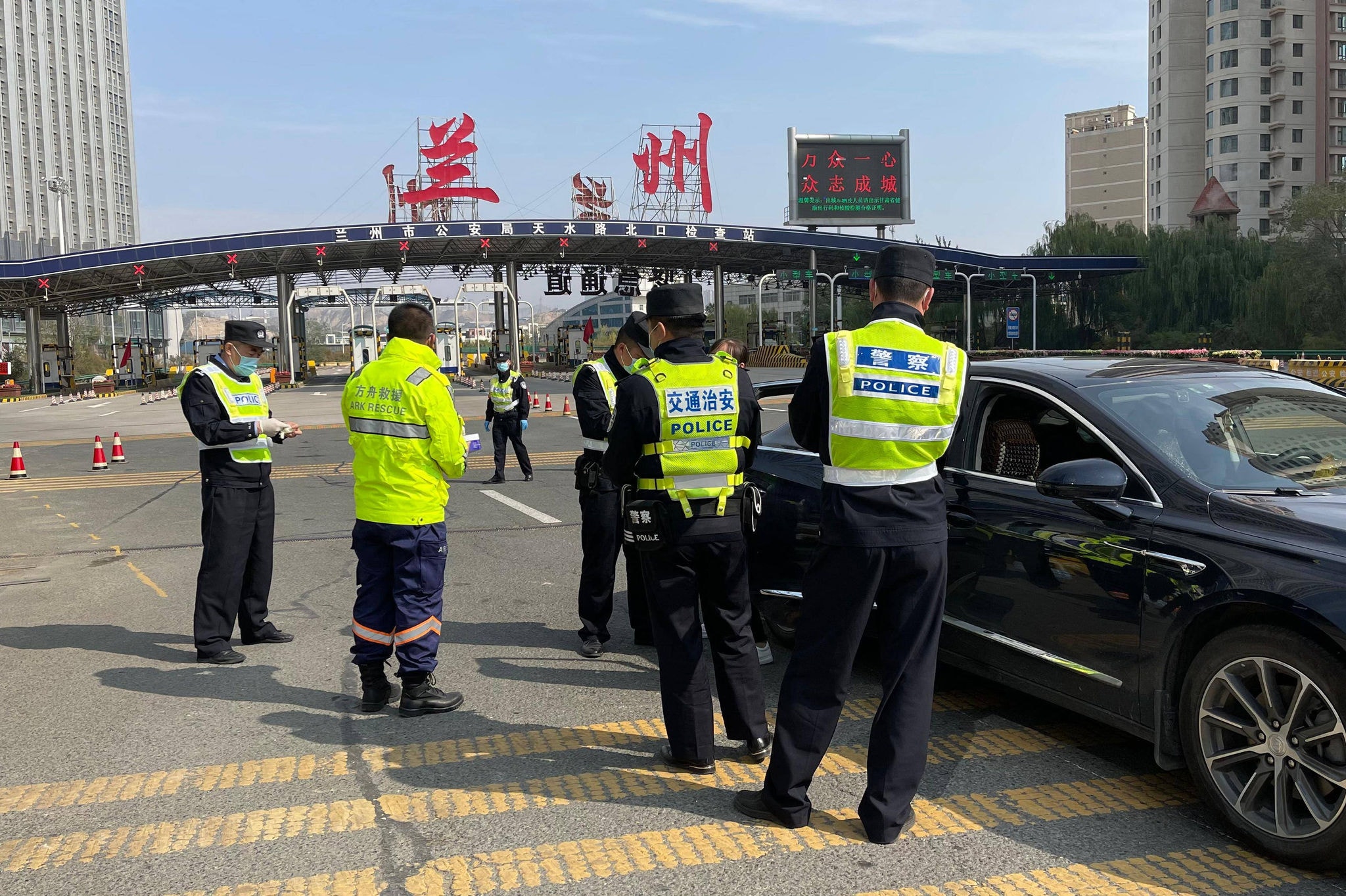 Policiais fiscalizam testes de Covid na entrada de Lanzhou