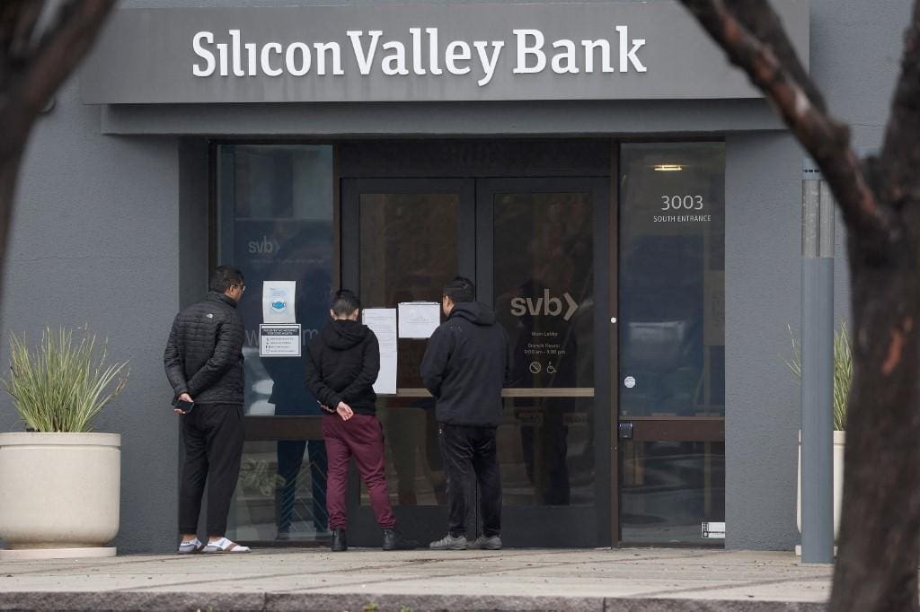 Funcionários Silicon Valley Bank (SVB) leiam mensagem sobre o fechamento da instituição, nos EUA