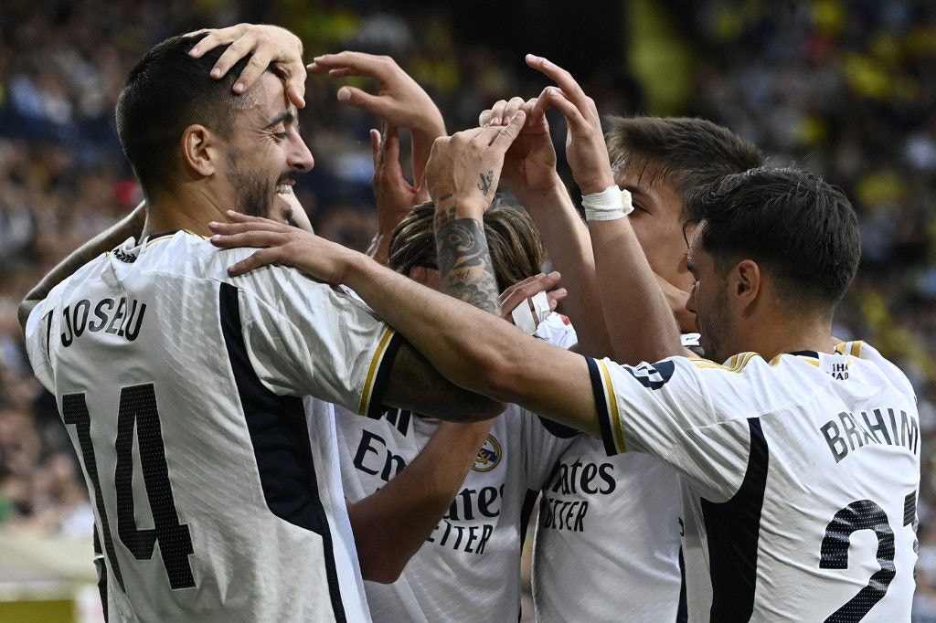 Real Madrid's Spanish forward #14 Joselu (L) celebrates scoring his team's second goal during the Spanish League football match between Villarreal CF and Real Madrid CF at La Ceramica stadium in Vila-real on May 19, 2024. (Photo by JOSE JORDAN / AFP)