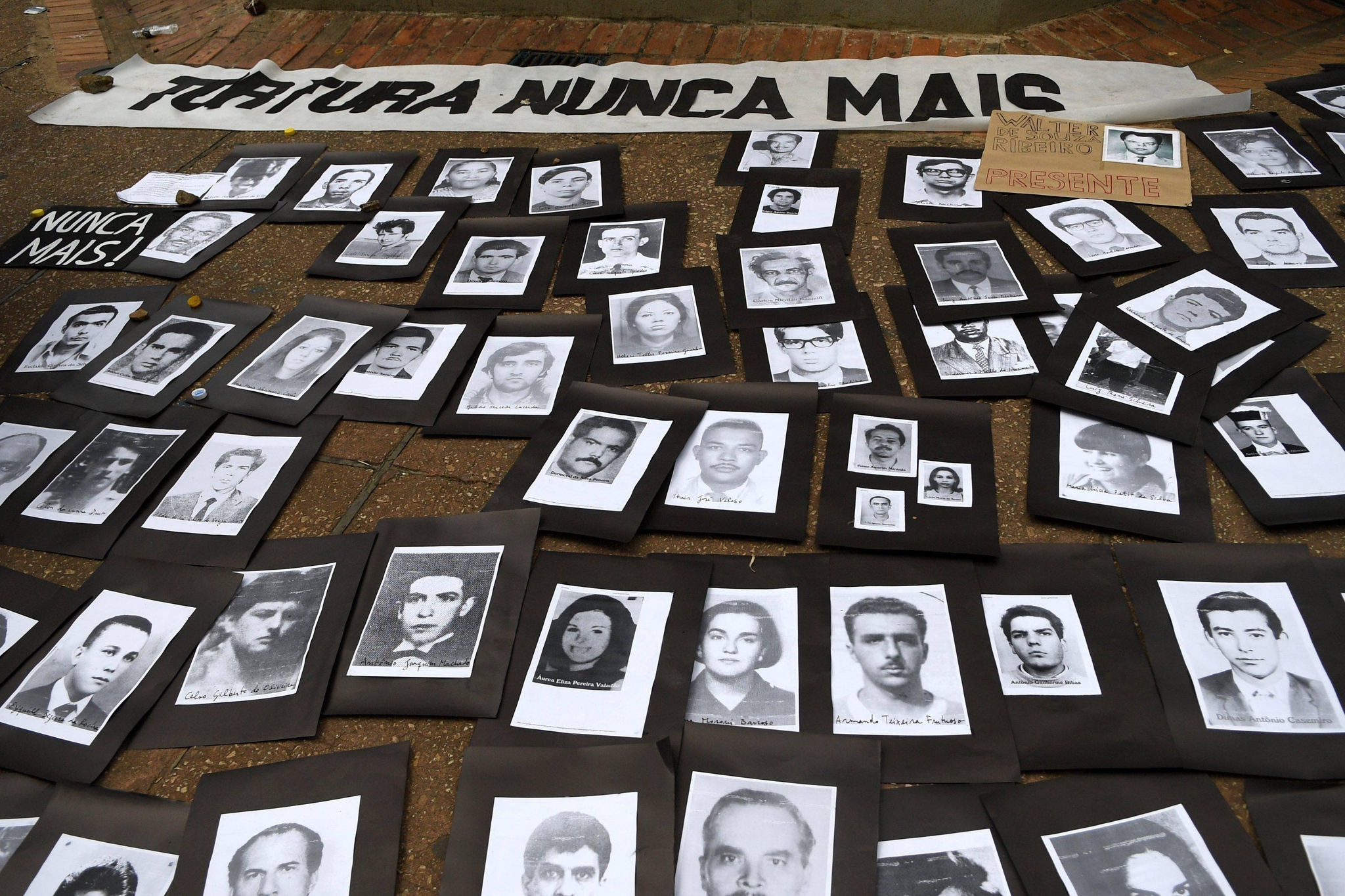 Fotos de vítimas da ditadura militar expostas em ato realizado por defensores dos direitos humanos