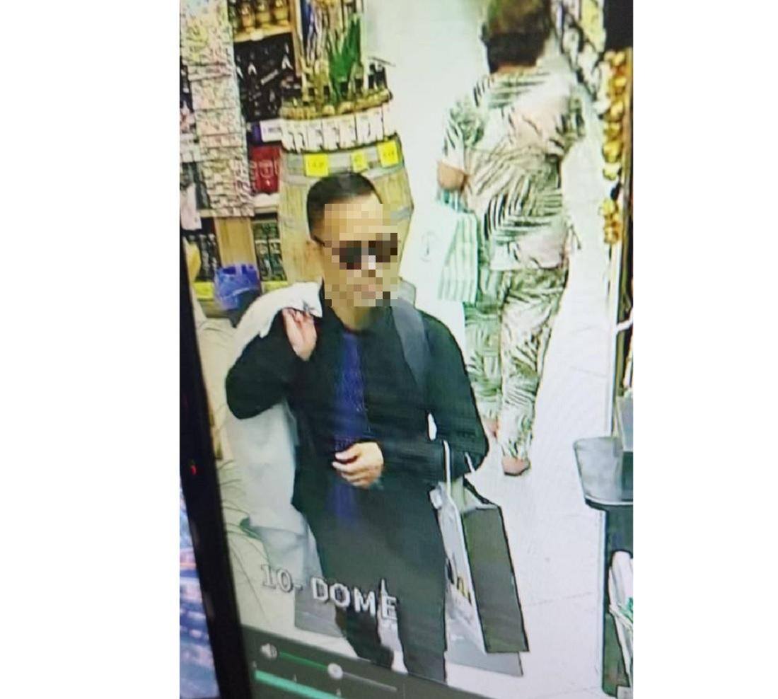 Imagem da câmera de segurança mostra o suspeito caminhando, com o blazer no ombro, dentro do suspermercado