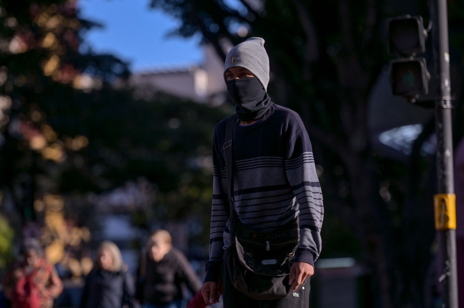 Foto mostra jovem agasalhado em rua de BH