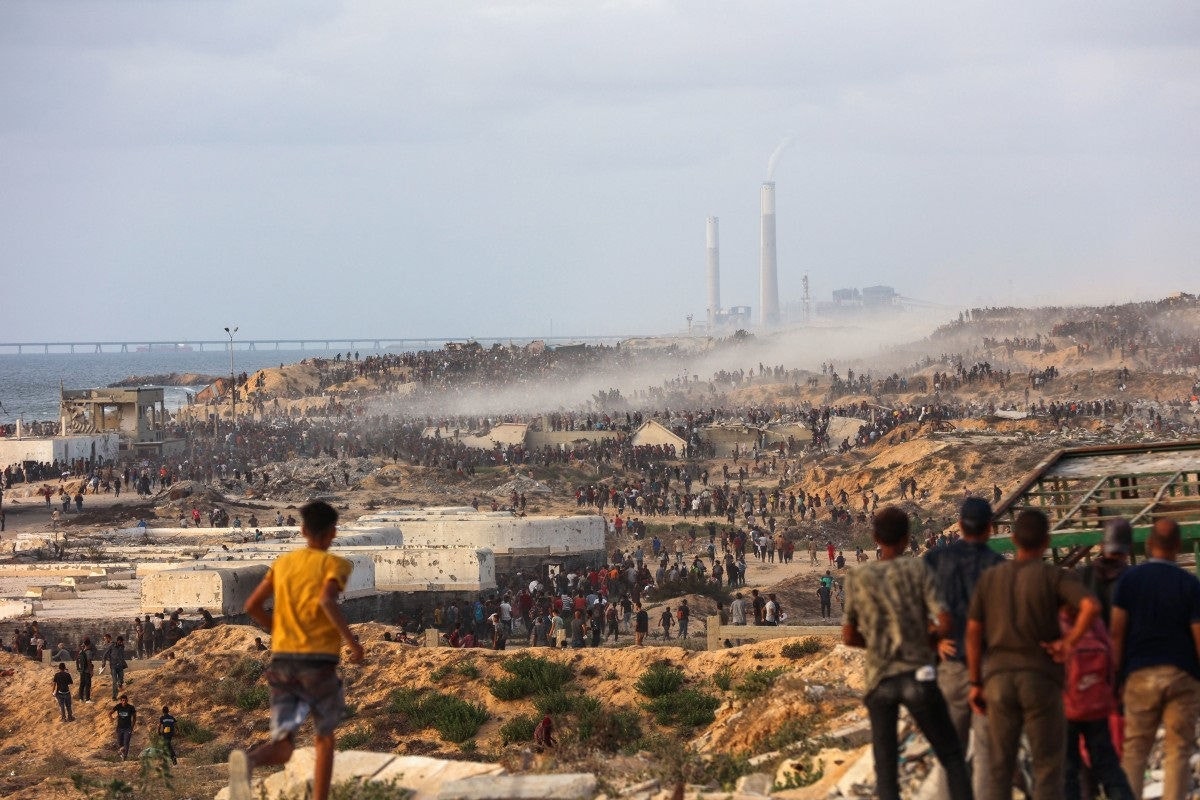 Palestinians gather on a coastal path west of Beit Lahia to attempt to get food aid on July 29, 2025, after aid trucks entered the Israel-besieged Gaza Strip from the northern Zikim border crossing. (Photo by Omar AL-QATTAA / AFP)