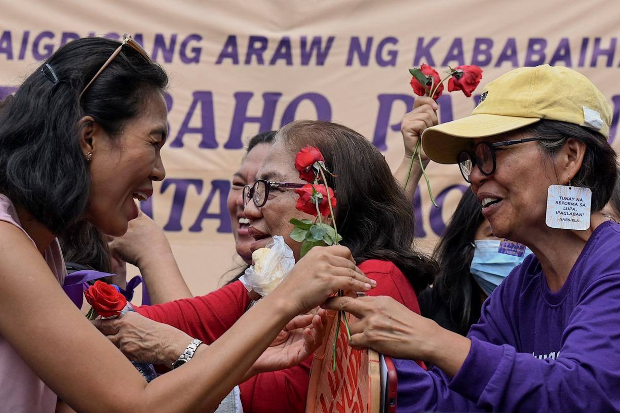 Mulheres dão rosas umas às outras durante uma manifestação para marcar o Dia Internacional da Mulher em Liwasang Bonifacio, em Manila, em 8 de março de 2023.